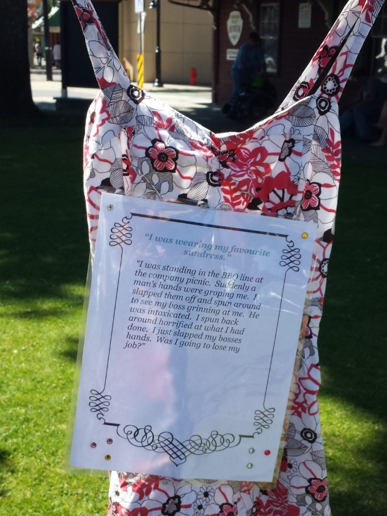 A red patterned dress hanging with a written note on it.